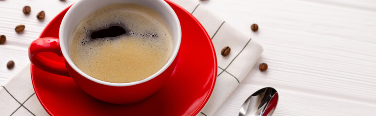 Coffee cup and coffee beans on white wooden background