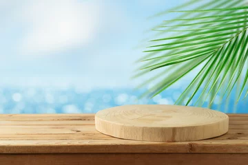  Empty wooden log on rustic table over blurred sea beach background.  Summer mock up for design and product display. © maglara