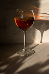shining glass of rose wine in sun light and shadow