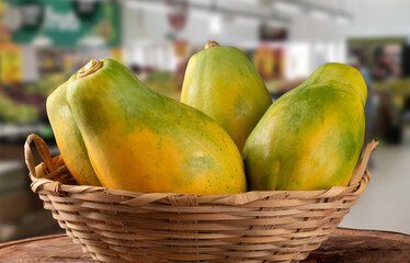 Ripe papaya fruit in basket on blurred background