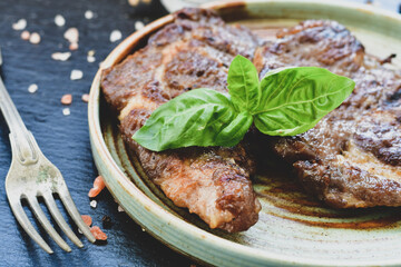 Grilled juicy pork steak, BBQ dishes on black background with copy space. Top view, flat lay food