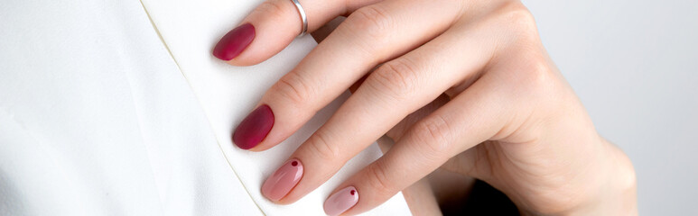 Beautiful womans hand with a pink manicure in minimal style