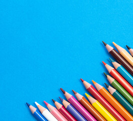 Coloring pencils isolated on blue background close up concept with copy space for text