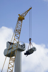 A crawler crane is hoisting the gearbox of a new wind turbine - obrazy, fototapety, plakaty