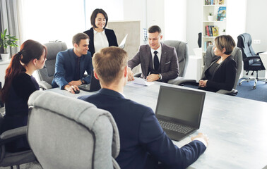 Group of young successful businessmen lawyers communicating together in a conference room while working on a project