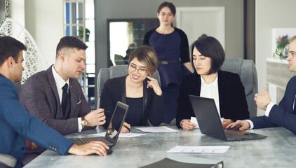 Group of young successful businessmen lawyers communicating together in a conference room while working on a project