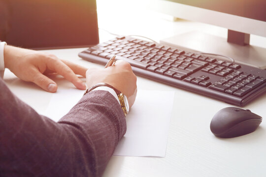 Young business man working at the computer and papers on the table