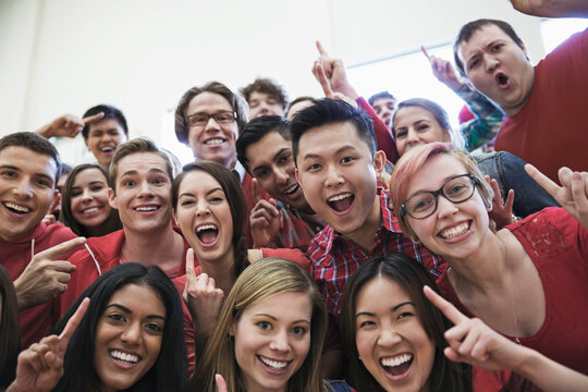 Portrait Of Large Group Of Students Cheering At College Sporting Event