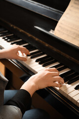 Fototapeta premium Young woman playing piano, closeup. Music lesson