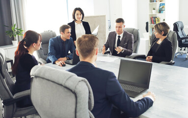 Group of young successful businessmen lawyers communicating together in a conference room while working on a project