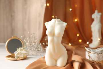 Composition with beautiful female body shaped candle on white table