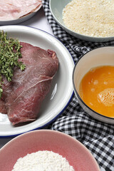 Preparation of traditional Milanese escalope with flour, egg, breadcrumbs, cheese and ham