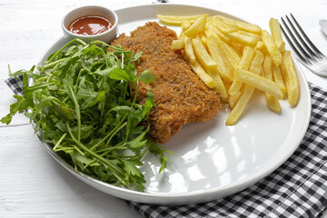 Homemade traditional Milanese veal escalope with french fries