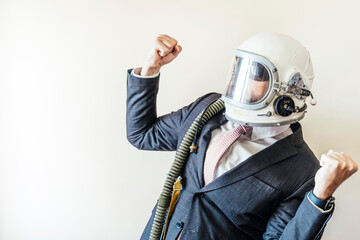 Businessman with astronaut helmet celebrating euphoric raising fists