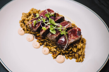 Un exquisito plato gourmet de tataki de ternera sobre un arroz con especias en un restaurante europeo