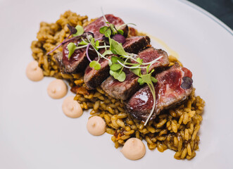 Un exquisito plato gourmet de tataki de ternera sobre un arroz con especias en un restaurante europeo