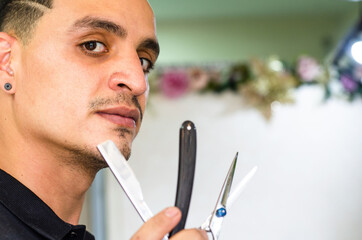 Barber Shop. Barber holds a razor to shave his beard.