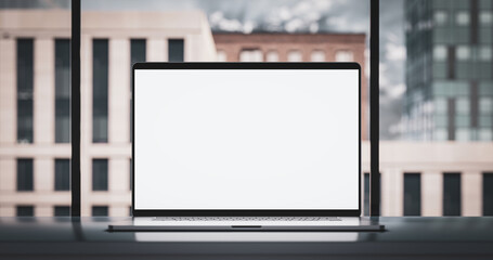 Laptop with frameless blank screen mockup template on the table in industrial office loft interior
