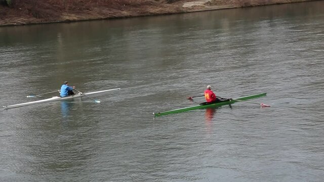 Man rowing in a single scull canoe. River Po, Torino, Italy
