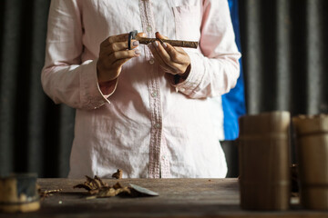 Hands of a woman rolling a cuban cigar in a beautfiul ambient. Vinales, Cuba