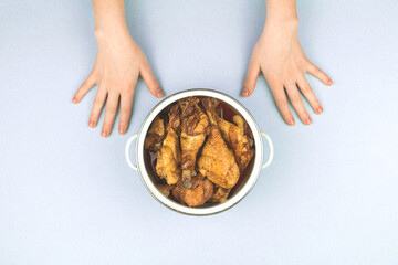 Concept of a happy person child waiting to start dinner, roasted chicken in a saucepan, child starvation, top view photo