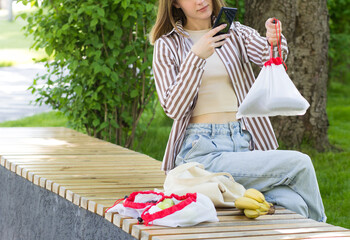 Woman taking pictures of zero waste sustainable cotton bag. Eco blogger. Ecological lifestyle