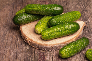 Crispy cucumbers on a wooden stand, marble background