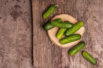 Crispy cucumbers on a wooden stand, marble background