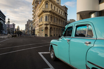 Old car on streets of Havana with colourful buildings in background. Cuba
