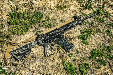 A modern automatic American carbine lying on the ground in the mud. Weapons in extreme conditions....