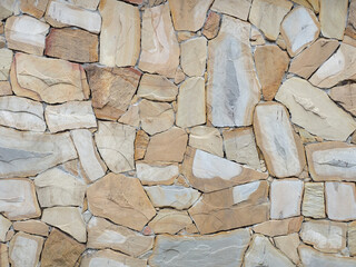 A wall with chaotically laid light granite tiles. Fullscreen photos. Not seamless texture