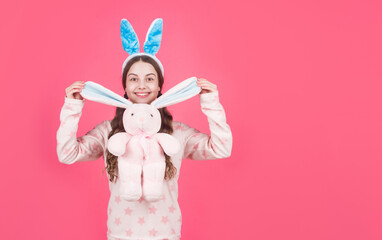 happy easter teen girl in bunny rabbit ears and pajamas play with toy, copy space, easter
