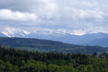 Naklejka na ściany i meble Landscape with mountains in the background seen from wooden lookout named Loorenkopfturm (Loorenkopf tower). Photo taken May 18th, 2021, Zurich, Switzerland.