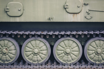 Side part of modern military combat equipment. Wheels and tracks of the tank.