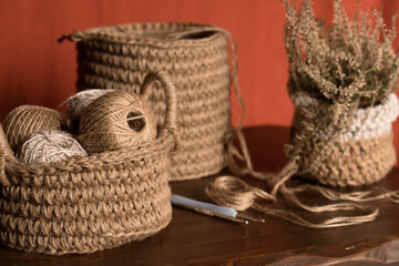 Obraz premium jute crochet material kit: threads, crochet hooks and leather tags in a basket on table