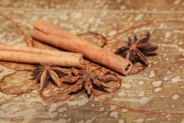 Star anise and cinnamon sticks on a brown background