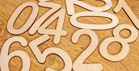 Flatley, top view on wooden numbers from zero to nine scattered randomly on wooden background