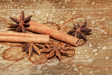 Star anise and cinnamon sticks on a brown background