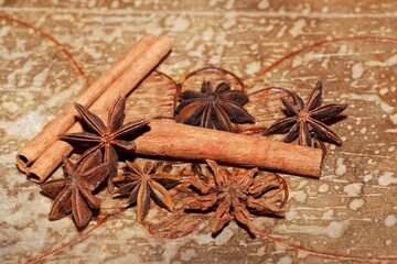 Star anise and cinnamon sticks on a brown background