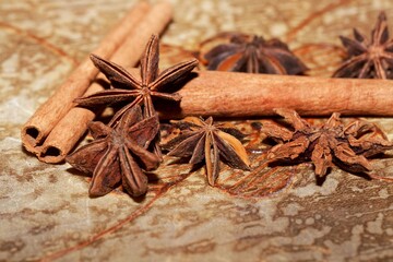 Obraz na płótnie Canvas Star anise and cinnamon sticks on a brown background