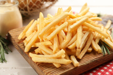 Delicious french fries served on white wooden table, closeup