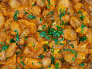 Cooked beans in tomato sauce close up view