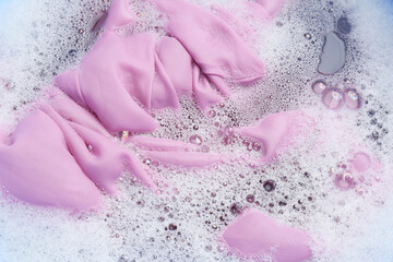 Fototapeta premium Color clothing in suds, top view. Hand washing laundry