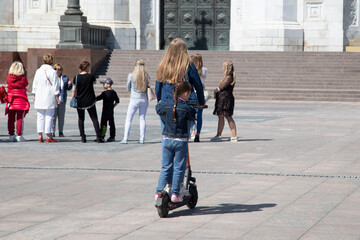 Obraz premium Girls ride a scooter. Electric scooter rental in Moscow.