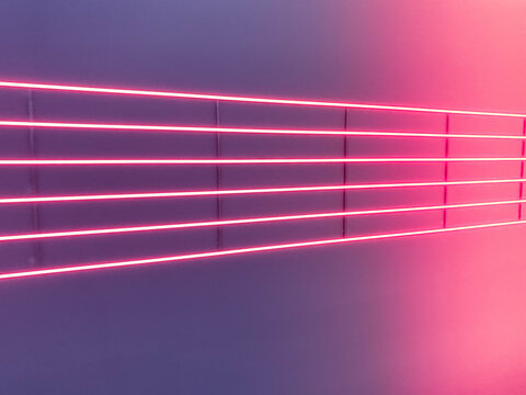 Texture of purple and pink glowing bright neon LED multicolored laser abstract stripes and lines from parallel lamps. The background