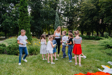 Obraz premium A teacher teaches a class of children in an outdoor Park. Back to school, learning during the pandemic
