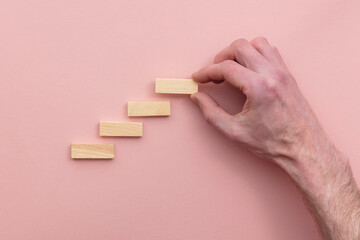Hand choosing a wooden block from a set of steps. Business choice concept