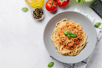 Traditional italian pasta spaghetti with bolognese meat sauce and parmesan on a white concrete, stone table background. Flat lay, top view, copy space