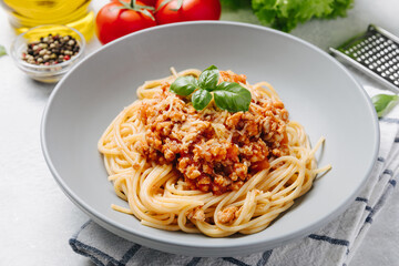 Traditional italian pasta spaghetti with bolognese meat sauce and parmesan on a white concrete, stone table background. Close up