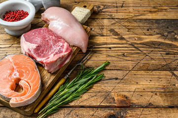 Animal protein sources meat, fish, and poultry. Raw steaks. wooden background. Top view. Copy space